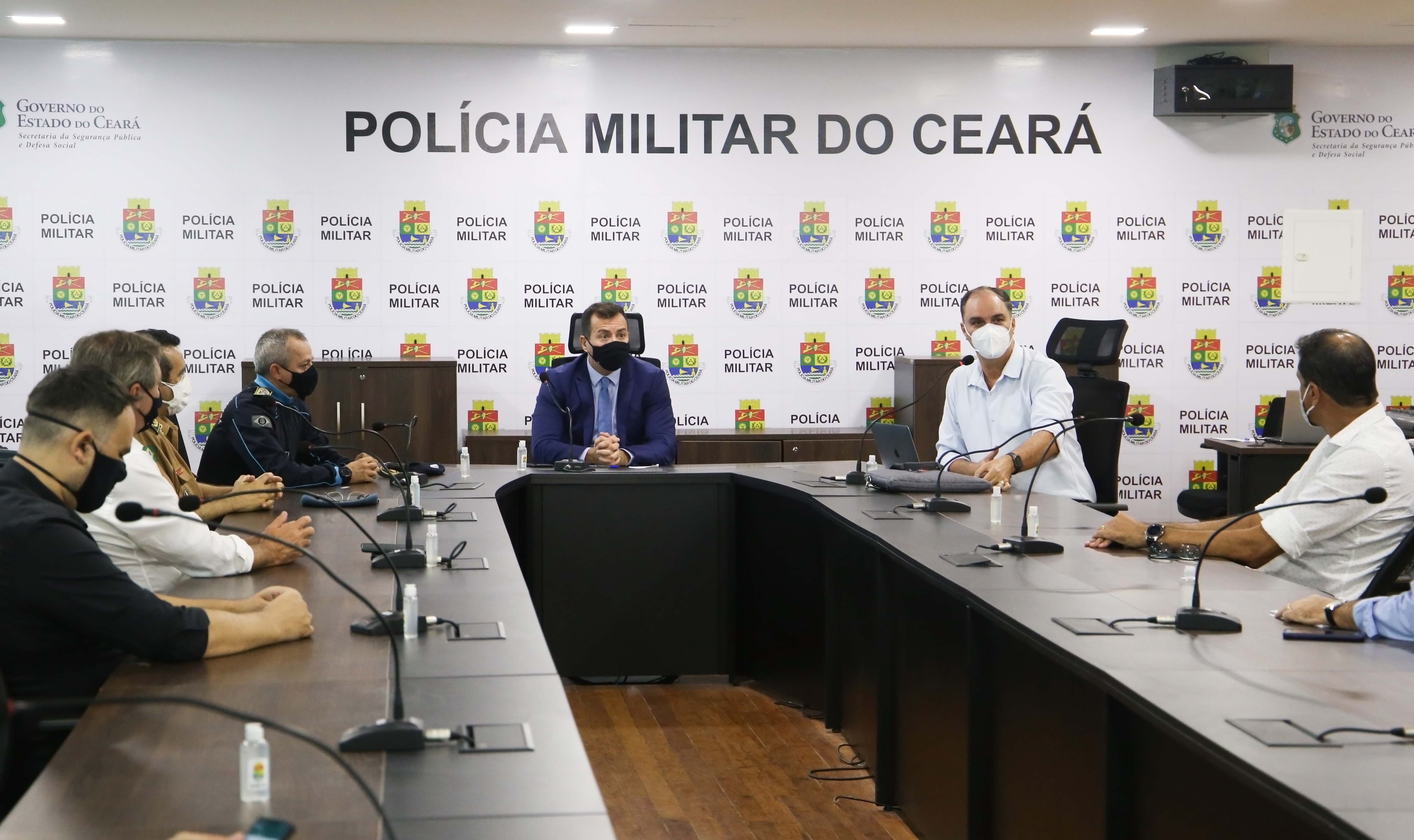 uma sala de reunião com um grupo de pessoas sentado à mesa